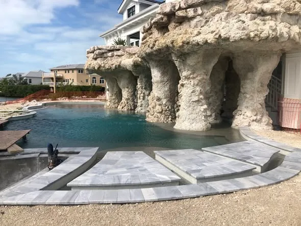 Custom grotto pool built into Keys limestone on Key Haven, with a curved marble sun-deck and open water beyond